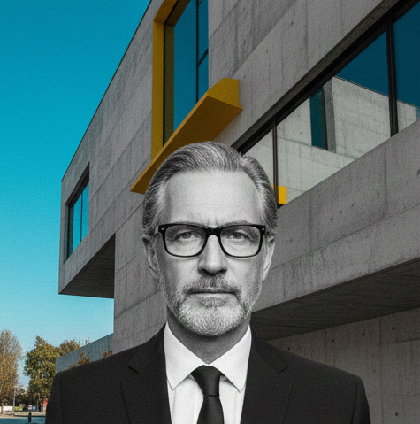 Headshot of Klaus, lead architect, in a brutalist architectural setting
